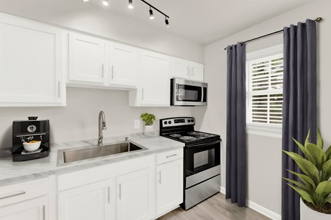 a kitchen with white cabinetry and black appliances and a sink
