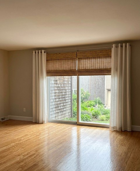 A room with a sliding glass door leading to a garden.