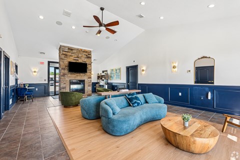A living room with a blue couch and a fireplace.