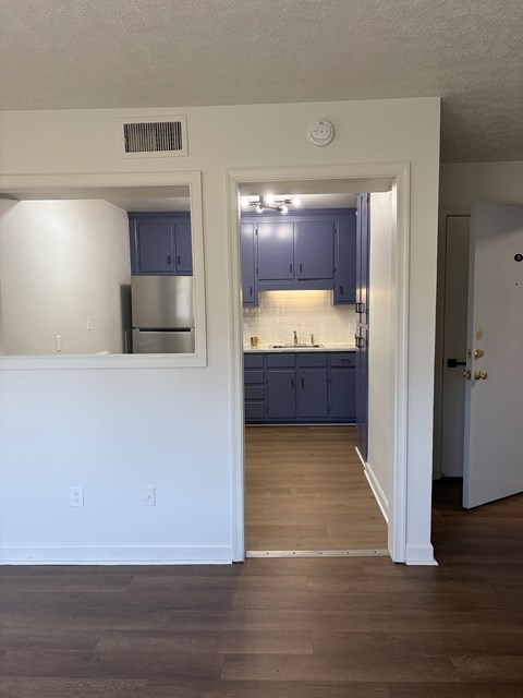 A kitchen with blue cabinets and a white wall.
