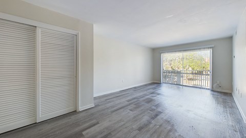 A room with a sliding door and a balcony.