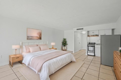 A bedroom with a large bed and a painting on the wall.