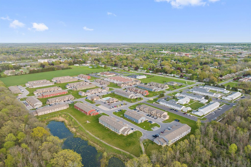an aerial view of a college campus with trees and a body of water
