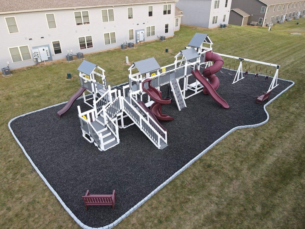a playground is shown in the yard of an apartment building