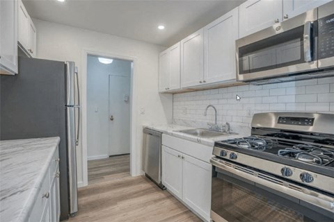 a kitchen with white cabinets and stainless steel appliances