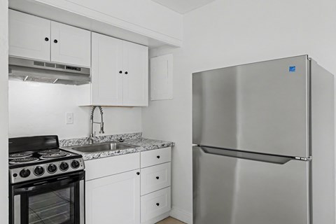 A modern kitchen with a stainless steel refrigerator and black stove.