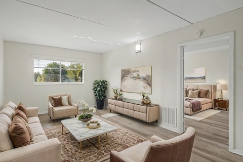 A living room with a large painting on the wall and a couch with a pillow on it.