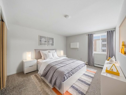 A bedroom with a large bed and a window with curtains.