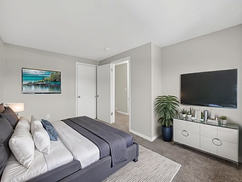 A bedroom with a bed, a dresser, and a painting on the wall.