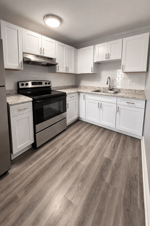 A kitchen with white cabinets and a black stove top oven.