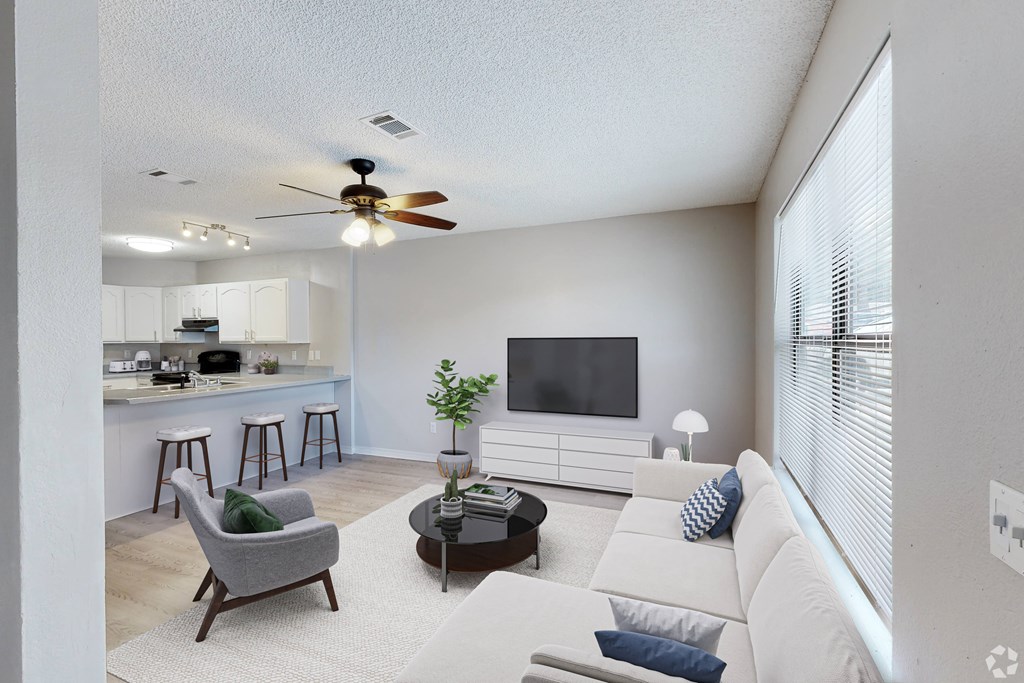 A living room with a grey armchair, a white sofa, and a black coffee table.