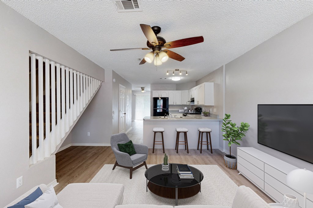 A living room with a bar area and a staircase.