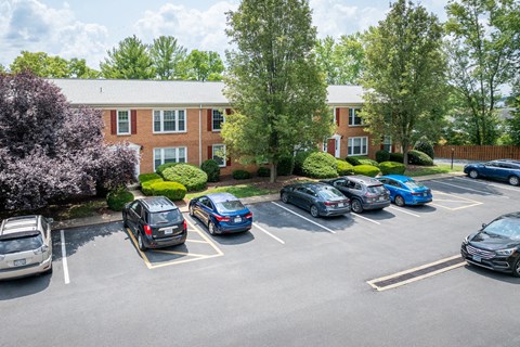 A parking lot with cars parked in front of a brick building.
