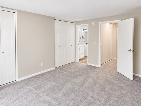 A room with a carpeted floor and white doors.