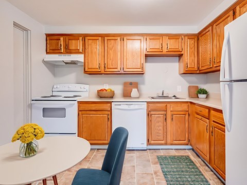 A kitchen with wooden cabinets and a white refrigerator.