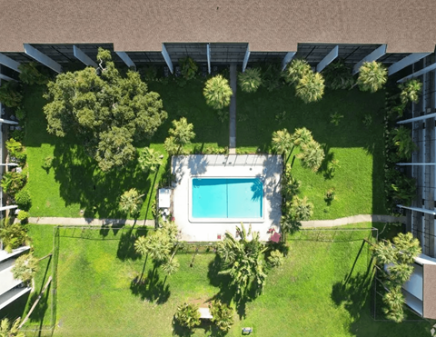 A swimming pool surrounded by green grass and trees.