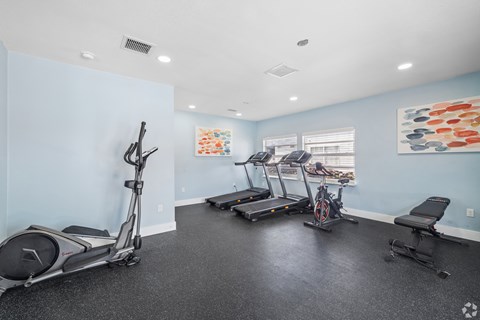 A spacious room with exercise equipment and a treadmill.