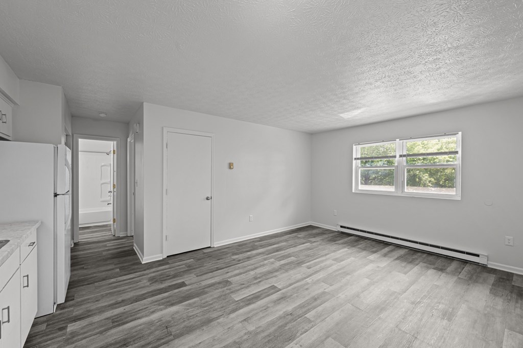 A kitchen with white appliances and a grey floor.