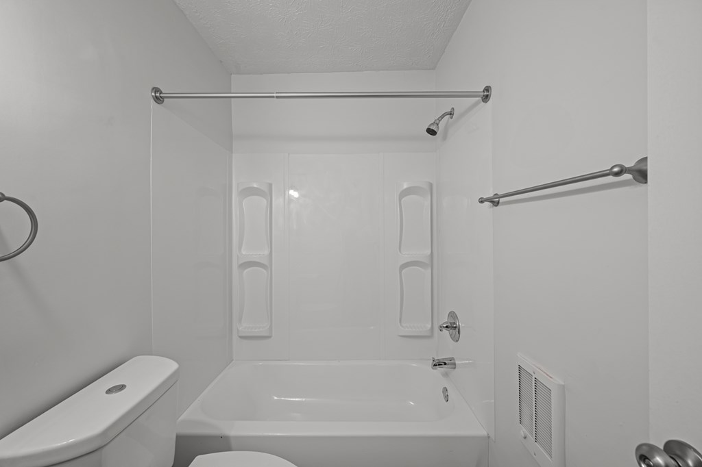 A white bathroom with a toilet, sink, and bathtub.