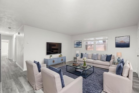 A living room with a grey carpet and a white sofa.
