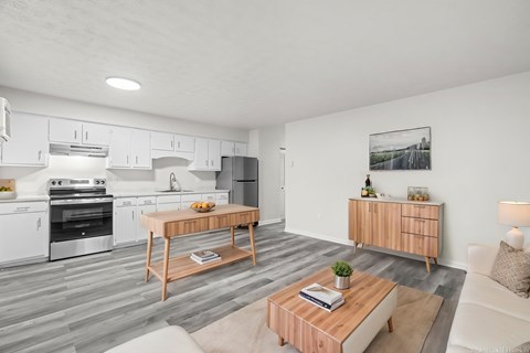 A modern kitchen with a wooden coffee table in the middle.