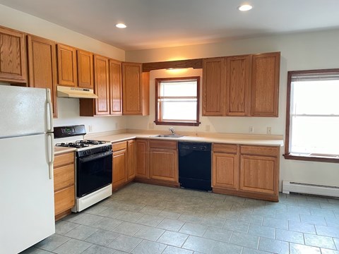 A kitchen with wooden cabinets and a white refrigerator.