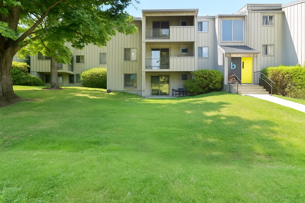 A grassy area in front of apartment buildings.