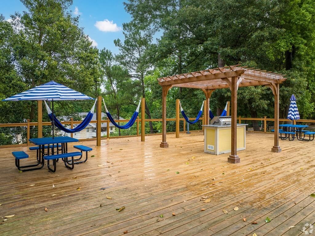 a large deck with hammocks and picnic tables
