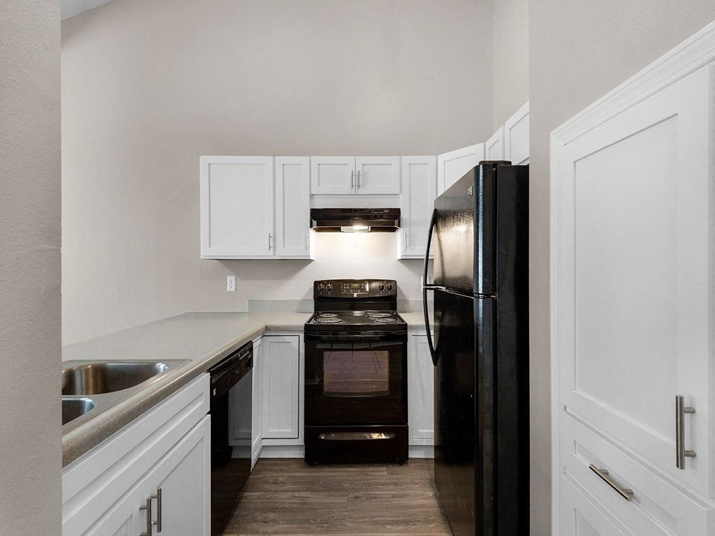 a kitchen with black appliances and white cabinets