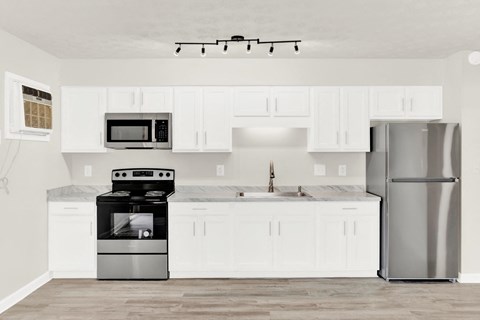 a white kitchen with stainless steel appliances and white cabinets