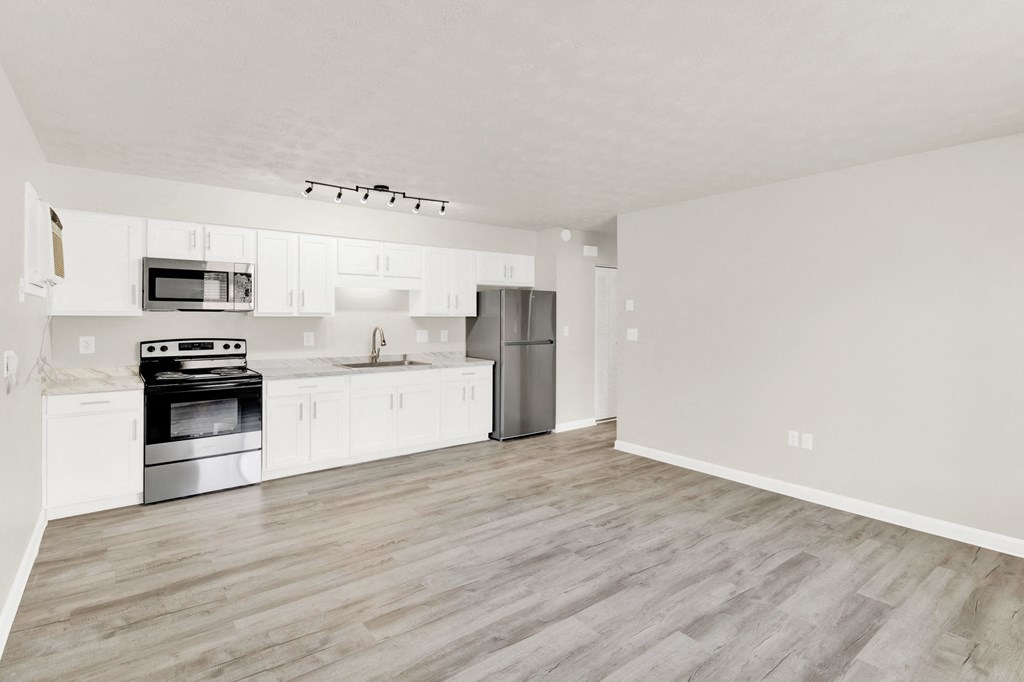 a spacious kitchen with white cabinets and stainless steel appliances