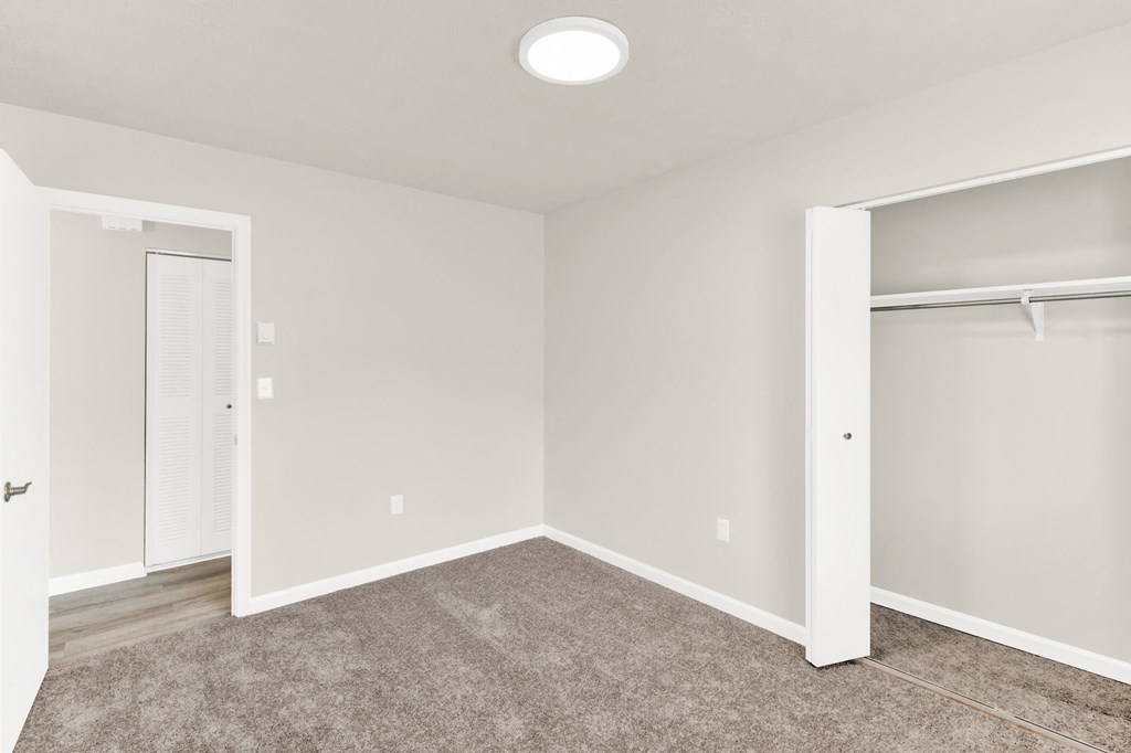 an empty bedroom with a closet and a door to a closet