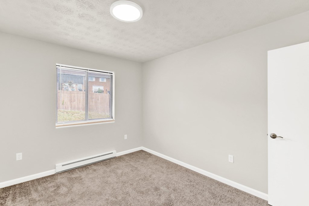 an empty room with carpet and a window