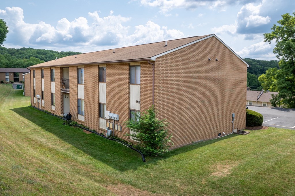 an image of a brick building with grass and trees