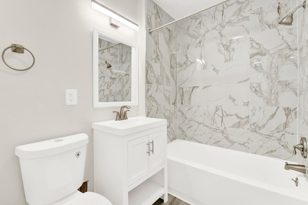 a white bathroom with a sink toilet and tub