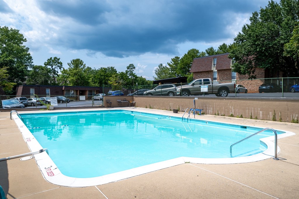 a swimming pool with a fence around it in front of a house