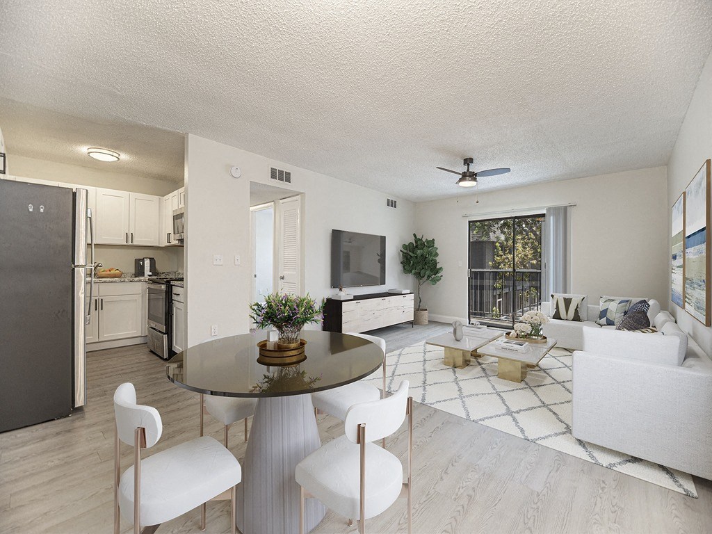 a living room with a table and chairs and a kitchen