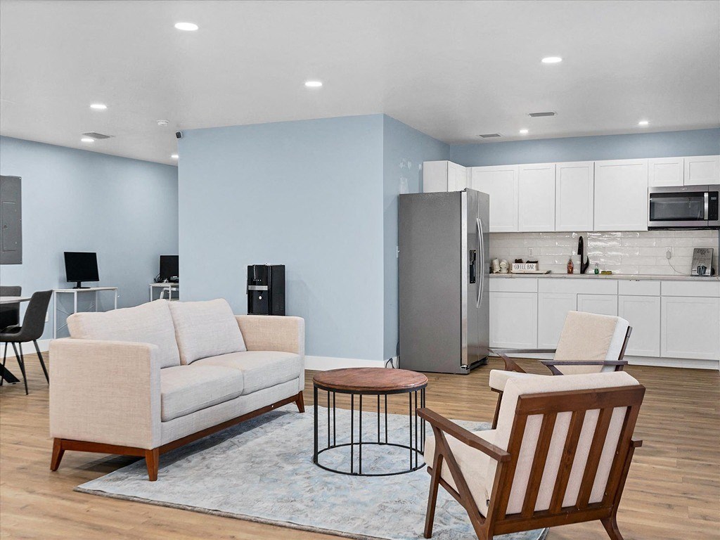 a living room with a couch and chairs and a refrigerator