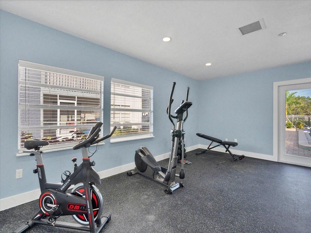 the gym has plenty of exercise equipment and windows