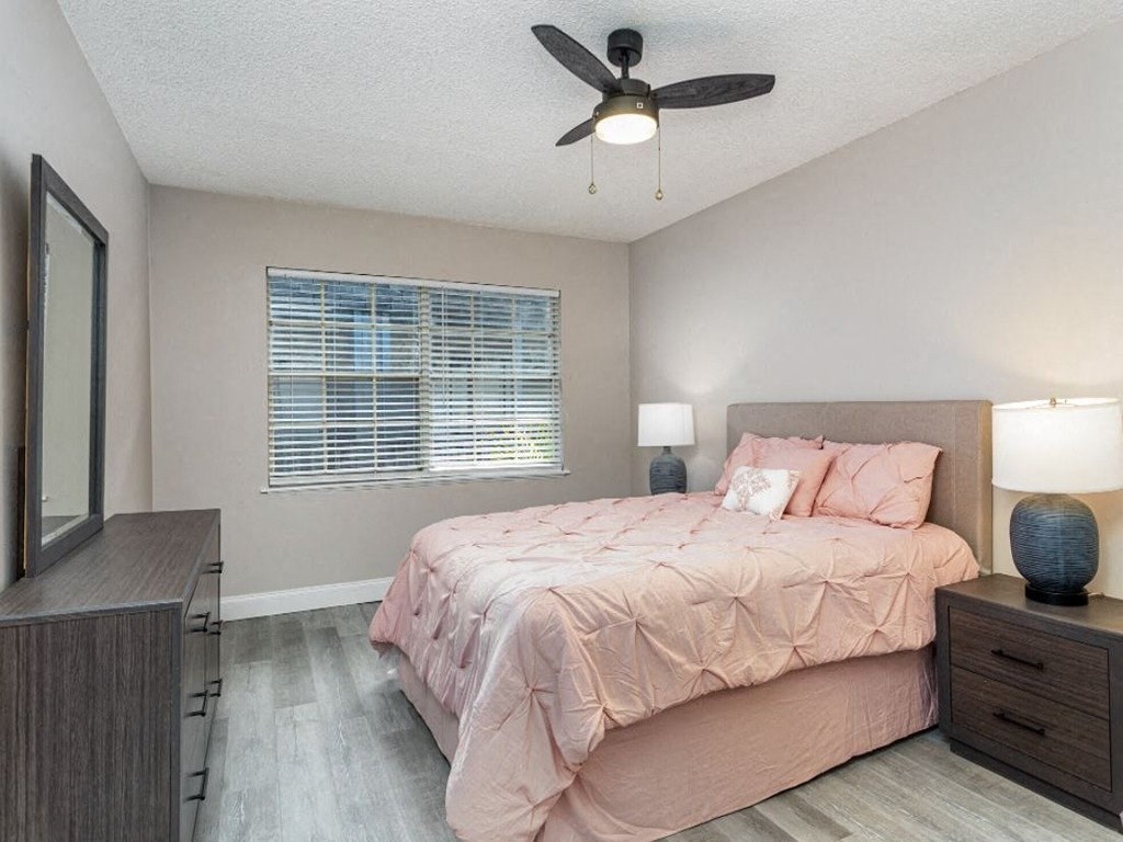 a bedroom with a bed and a ceiling fan