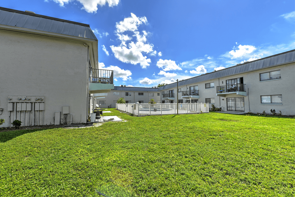 A grassy area in front of apartment buildings.