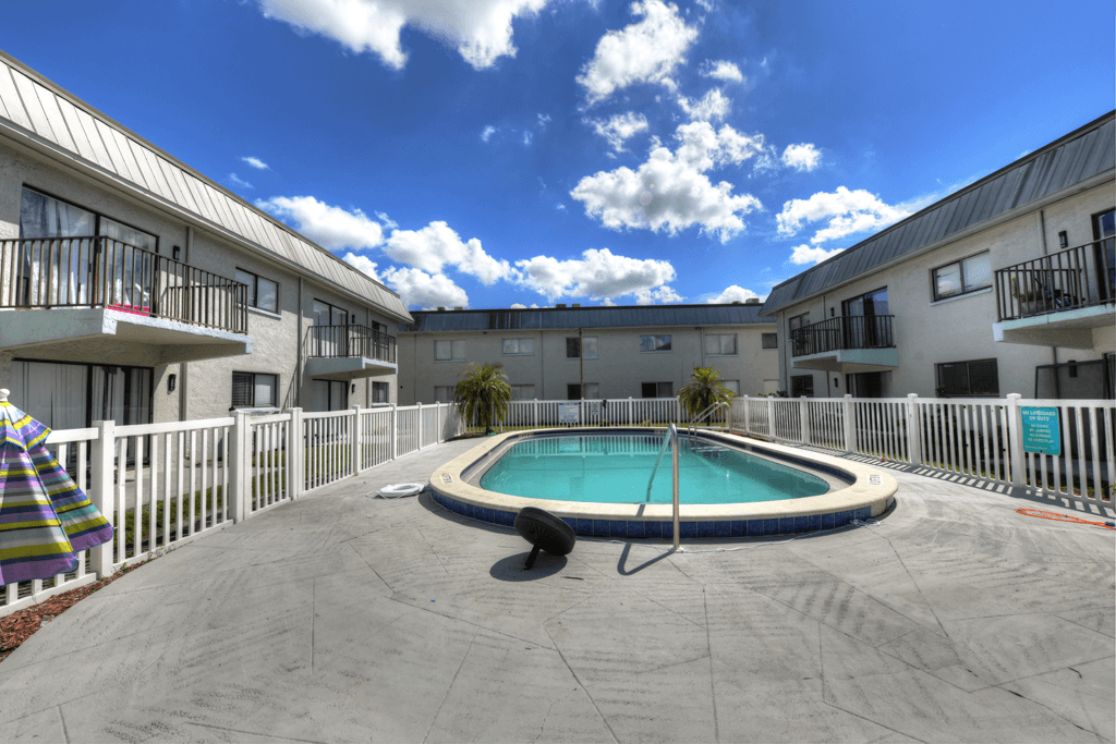 A swimming pool in a courtyard surrounded by buildings.