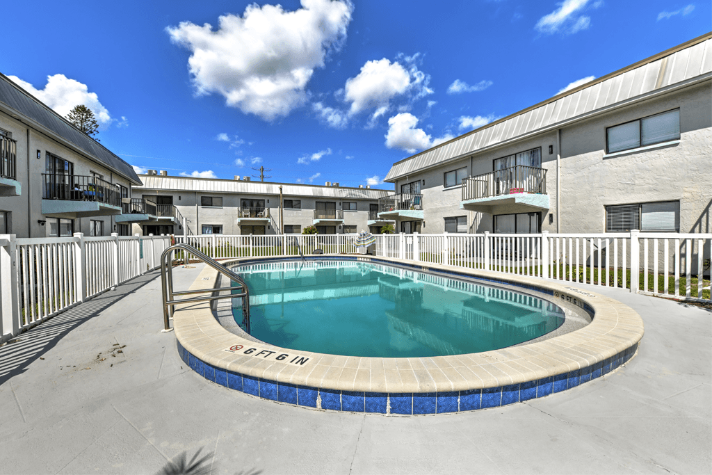 A swimming pool surrounded by a fence and buildings.