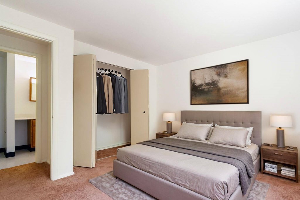 A bedroom with a large bed and a painting on the wall.