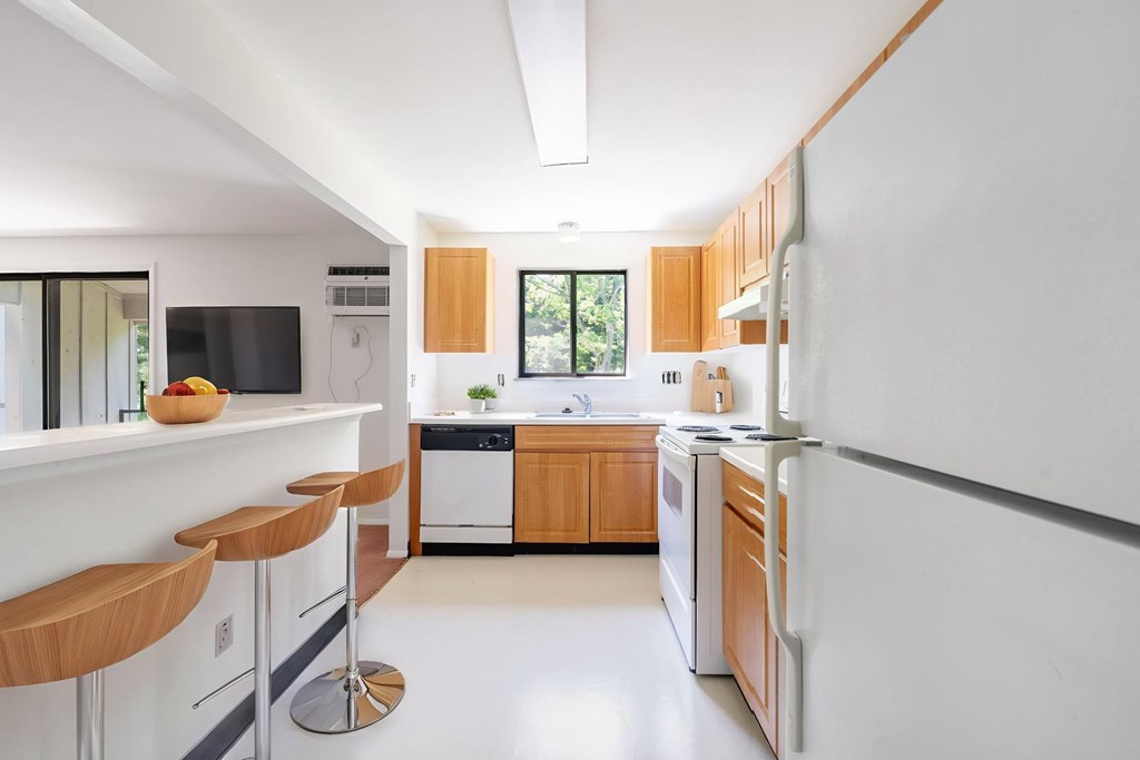 A modern kitchen with white appliances and wooden cabinets.