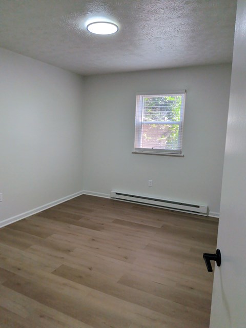 A room with a window and a radiator on the wall.