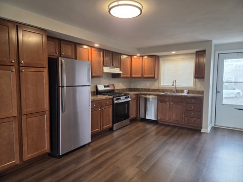 A kitchen with wooden cabinets and a refrigerator.