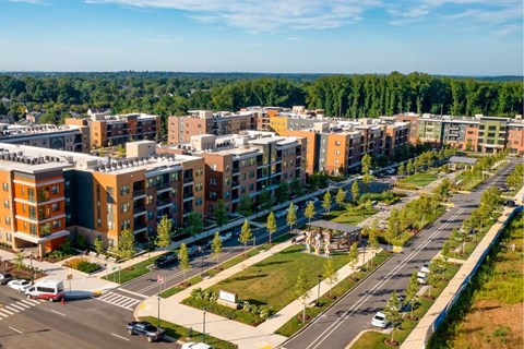 A view of a road with cars and apartment buildings.