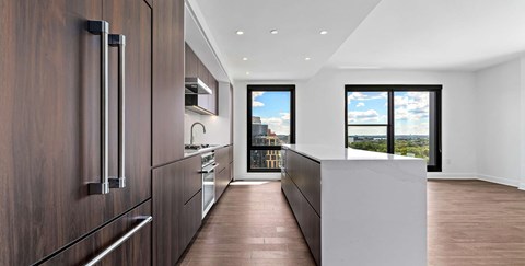 A modern kitchen with dark wood cabinets and a white counter.
