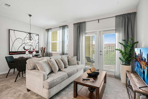 A living room with a grey couch, a coffee table, and a painting on the wall.